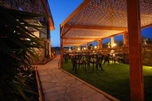 an outdoor patio with tables and chairs in a building at Lotus Konaklama Küçükköy in Ayvalık