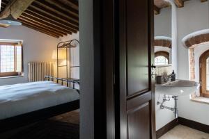 a bathroom with a bed and a sink in a room at Mulino di Pari - Where Time Slows in Pari