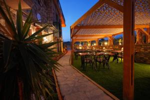 a patio with tables and chairs in a building at Lotus Konaklama Küçükköy in Ayvalık