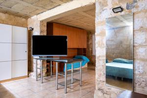 a living room with a tv and a table at Biancolino Apartments in Nardò