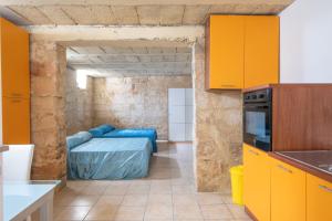 a kitchen with orange cabinets and a bed in a room at Biancolino Apartments in Nardò