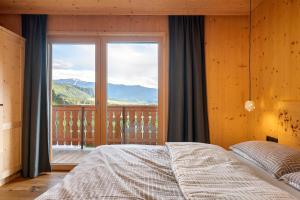 a bedroom with a bed and a large window at Felderhof in Villa Ottone