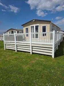 a house with a white fence in the grass at Bude 20 in Newquay