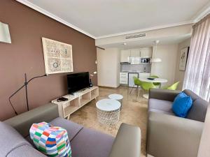 a living room with a couch and a tv at Apartamentos Plaza Picasso in Valencia