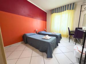 two beds in a room with red walls at VMHostel in Montecatini Terme