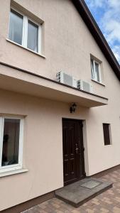a house with a brown door and two windows at Budapest Airport Smart panzio in Vecsés