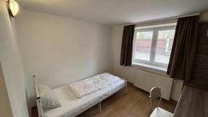 a small room with a bed and a window at Budapest Airport Smart panzio in Vecsés