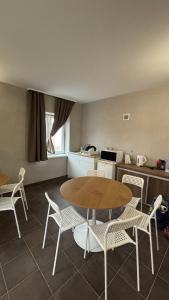 a kitchen with a table and some chairs and a table and a table at Budapest Airport Smart panzio in Vecsés