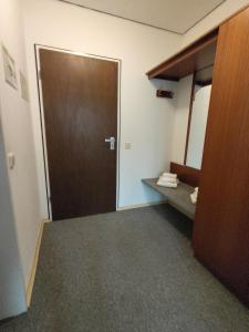 ein Zimmer mit einer Tür und einem Bett in einem Zimmer in der Unterkunft Hotel Nöhre in Wittingen