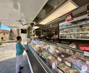 a woman standing in front of a food stand at Gîte Geoffroy in Montigny-sur-Aube