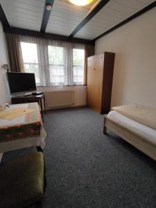 ein Zimmer mit zwei Betten und einem Schreibtisch mit Computer in der Unterkunft Hotel Nöhre in Wittingen + 6 Fotos