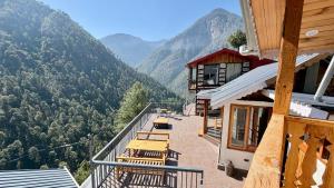 a balcony of a building with a view of mountains at Tirthan Chalet in Kulu