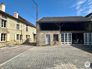 an old stone building with a cobblestone driveway at Gîte Geoffroy in Montigny-sur-Aube