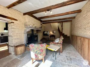 a living room with two chairs and a fireplace at Gîte Geoffroy in Montigny-sur-Aube