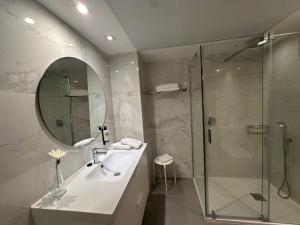 a bathroom with a shower and a sink and a mirror at Apartamentos Plaza Picasso in Valencia +48 photos