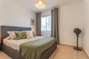 a bedroom with a bed with a fan and a window at Casa Oasis in Corralejo +26 photos