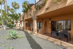 a house with a table and chairs outside of it at Casa Oasis in Corralejo