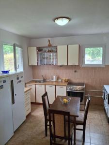 a kitchen with a table and a white refrigerator at Kuća za pravi odmor in Kolašin