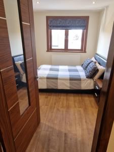 a small bedroom with a bed and a window at Self-catering extended family home in Edinburgh
