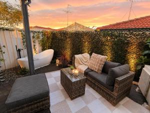 a backyard with a bath tub and a couch and a bath tub at Glamorous Getaway in Mandurah