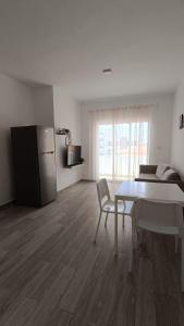 a white living room with a table and a refrigerator at One suite los corales in Punta Cana