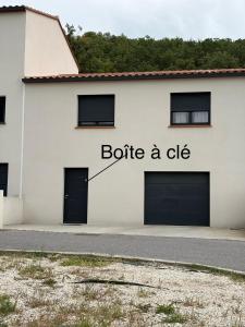 a white building with the words bottle a die on it at Maison Romarin in Le Boulou +3 photos