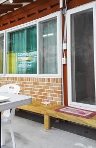 a porch with a bench and two windows at Najoo sunflowerstay in Naju