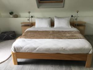a bedroom with a large bed with white sheets and pillows at Hoeve Sterrewijk in Aalter
