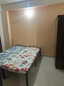 a small bed in a room with a bedspread on it at Suyakshi homestay in Pune