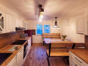 a kitchen with white cabinets and a wooden table at BLUE Reset in Ruciane-Nida