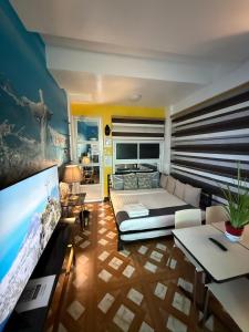 a living room with a large bed and a flat screen tv at Italy Condotel Darasa in Tanauan