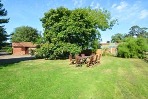 a picnic table and chairs under a tree in a field at 2 Bed in Lyng oc-864 in Lyng