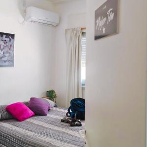 a bedroom with a bed with pink and purple pillows at Black Star Art Hostel in Neuquén +52 photos