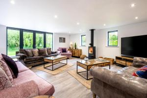 a living room with couches and a flat screen tv at 4 Bed in Steeple Bumpstead oc-hatch in Steeple Bumpstead
