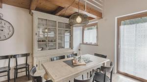 a dining room with a table and chairs and a clock at Sesto Senso in Ponte di Legno