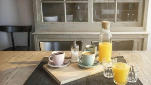 a table with two cups of coffee and a bottle of orange juice at Sesto Senso in Ponte di Legno