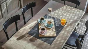 a wooden table with a plate of food and glasses of orange juice at Sesto Senso in Ponte di Legno