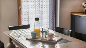 a table with a bottle of orange juice and two cups at Sesto Senso in Ponte di Legno
