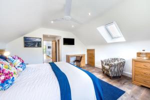 a bedroom with a large white bed and a chair at 4 Bed in Steeple Bumpstead oc-hatch in Steeple Bumpstead