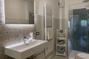 a white bathroom with a sink and a shower at Casa Castegner - Rooms in Seren del Grappa