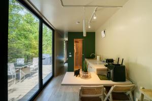 a room with a kitchen and a dining room with a table at Coniferis in Tomnatic