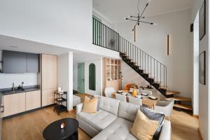 a living room with a white couch and a kitchen at Timeout Albatross Resort - Sea, Relax & Design in Ķesterciems