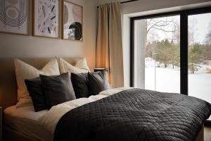 a bedroom with a bed with pillows and a window at Timeout Albatross Resort - Sea, Relax & Design in Ķesterciems +57 photos