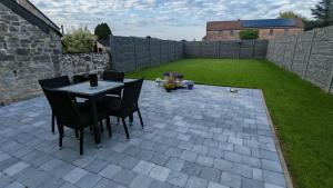 a patio with a table and chairs in a backyard at La Petite Auberge de Graux in Mettet