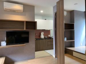 a living room with a television and a kitchen at Lunaria Maison - HCM Center Stay in Ho Chi Minh City