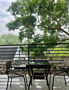 two chairs and a table on a patio with a tree at Ark Pai in Pai
