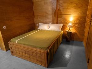 a small bed in a room with a lamp at Tree House Cabana Sigiriya in Sigiriya +2 photos