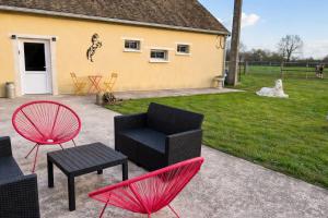a patio with two chairs and a table and chairs at Logement indépendant à la campagne proche du Pôle européen du Cheval et Circuit des 24h du Mans in Courceboeufs