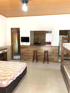 a room with two beds and a flat screen tv at Chalé Damata in Ubatuba
