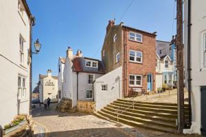 a group of buildings on a street with stairs at Host & Stay - Sea Haven in Staithes